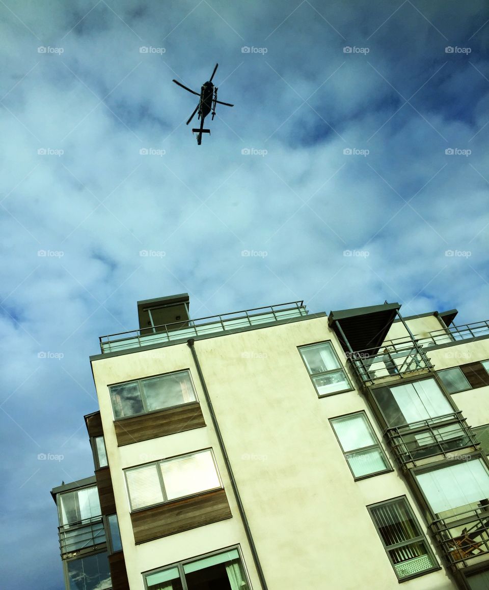 Helicopter. A helicopter is flying close to a building