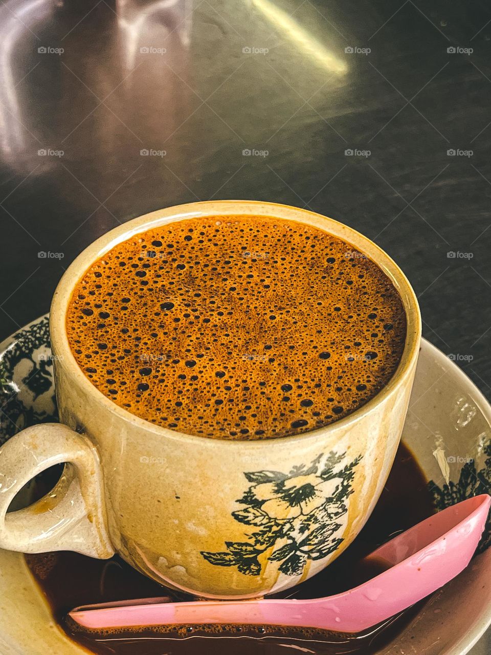 Close up view of bubbles on top of the coffee milk in ceramic vintage cup