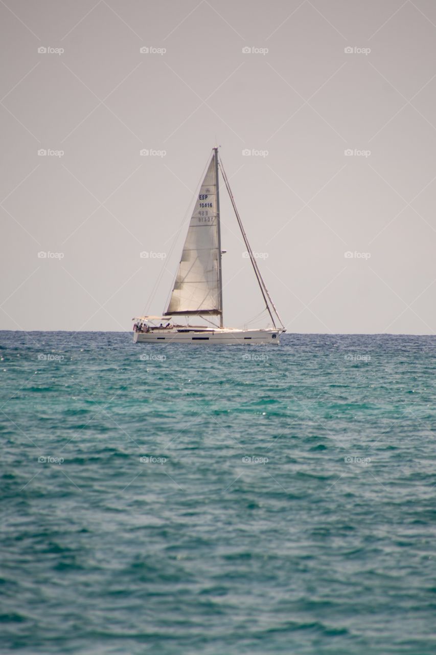 A sailing boat in the middle of the ocean 