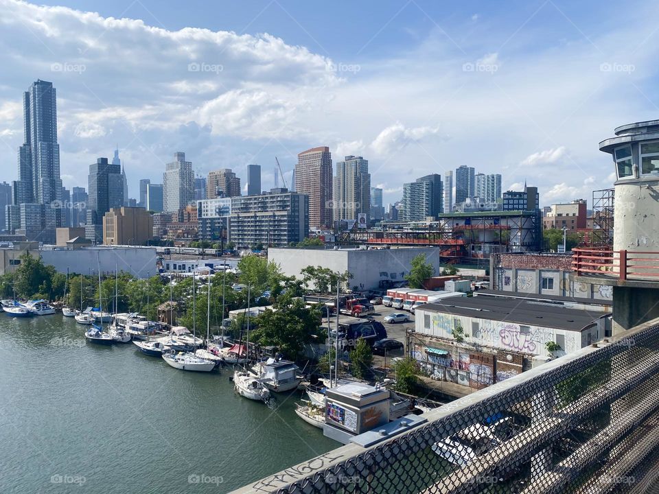 This is a beautiful view of the boats at “Newtown Creek” as seen from the “Pulaski Bridge” on a partially overcast late afternoon in June of 2023. Hypnotic Productions