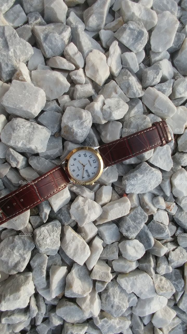 brown wrist watch on white stones