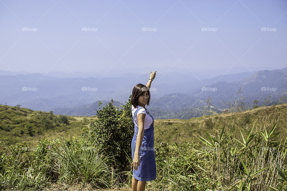 Portrait of Asean Woman The background of mountains and sky  at Nern Chang Suek  hills, Kanchanaburi, Thailand