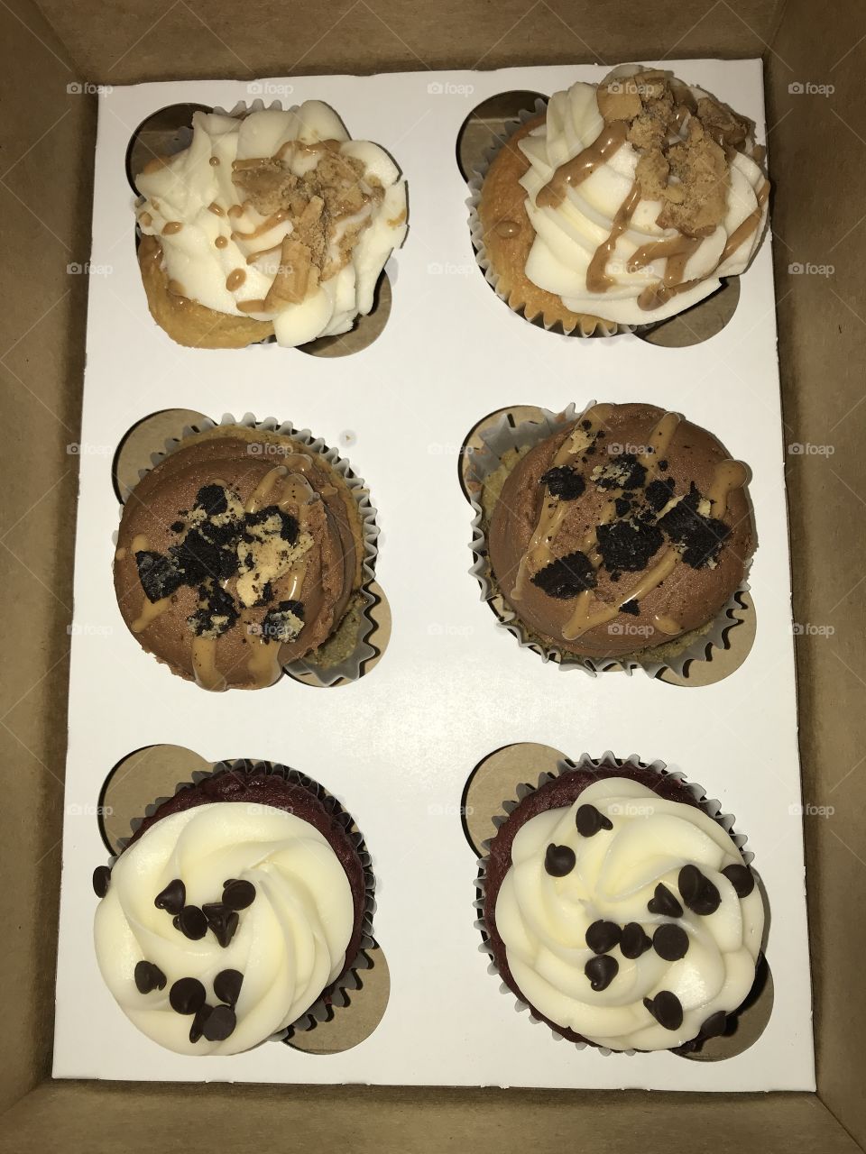 Gourmet cupcakes with frosting in a box