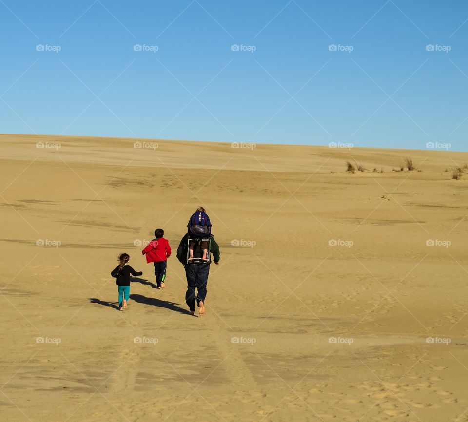 Rear view of people running in the desert