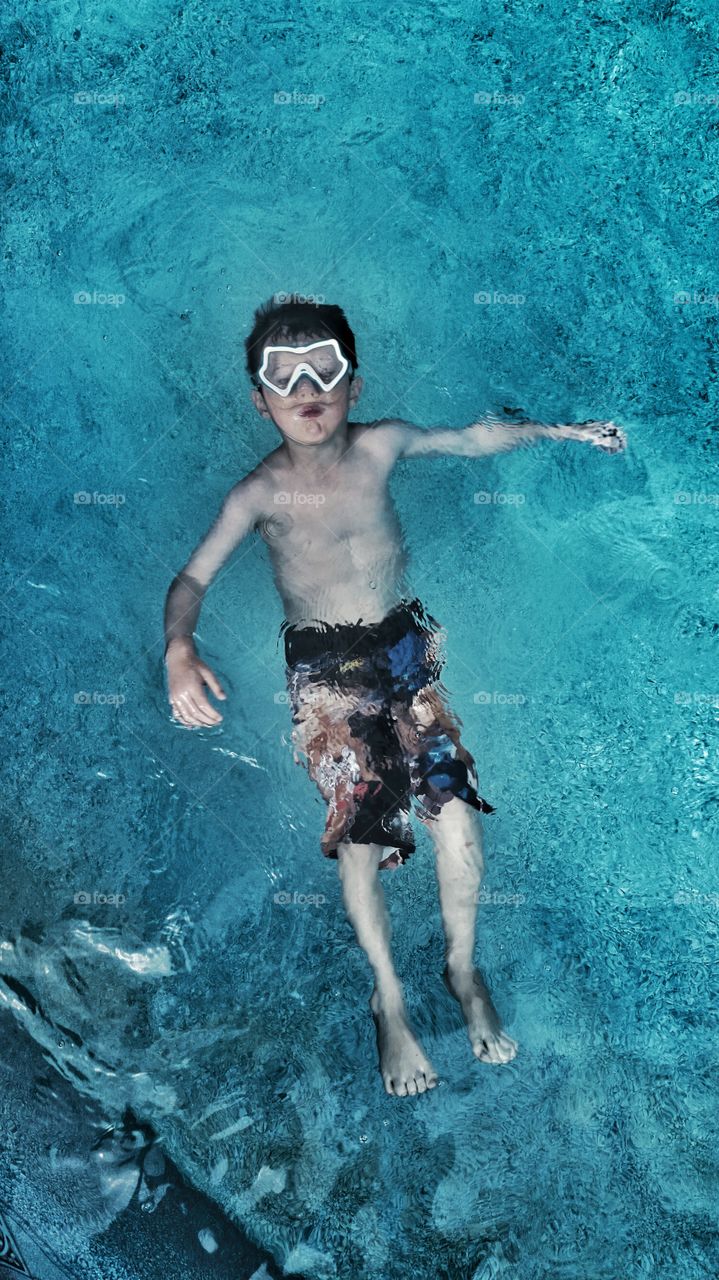 Elevated view of a boy swimming in pool