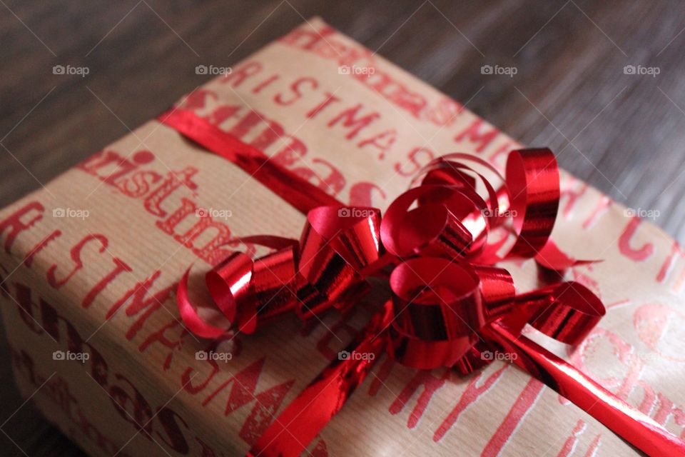 Christmas gift with red ribbon, text Merry christmas on the package