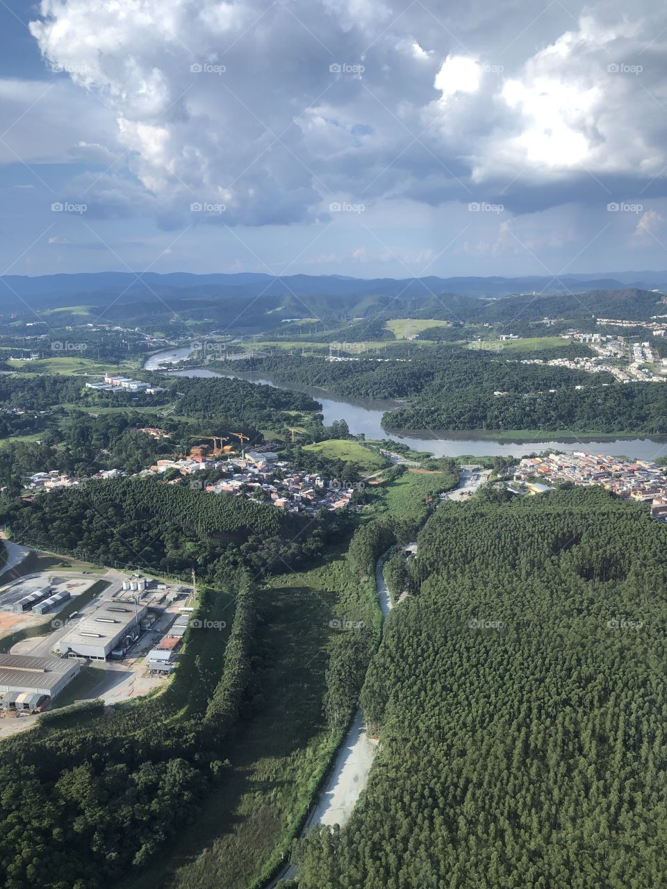 Nature and city view from above in a cloudy and rainy blue sky