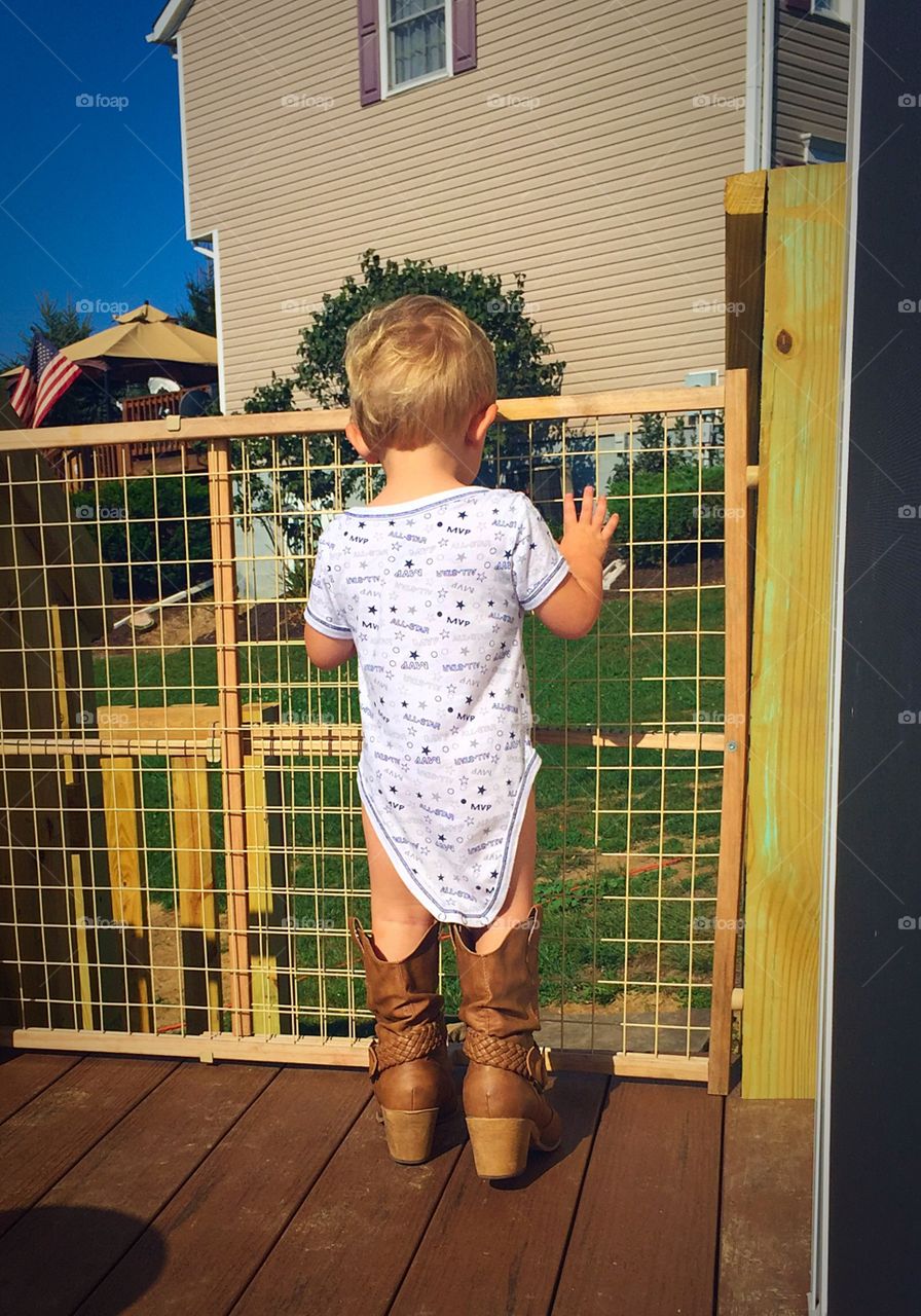 Boots . Cute little boy in mommy's boots, from behind. 