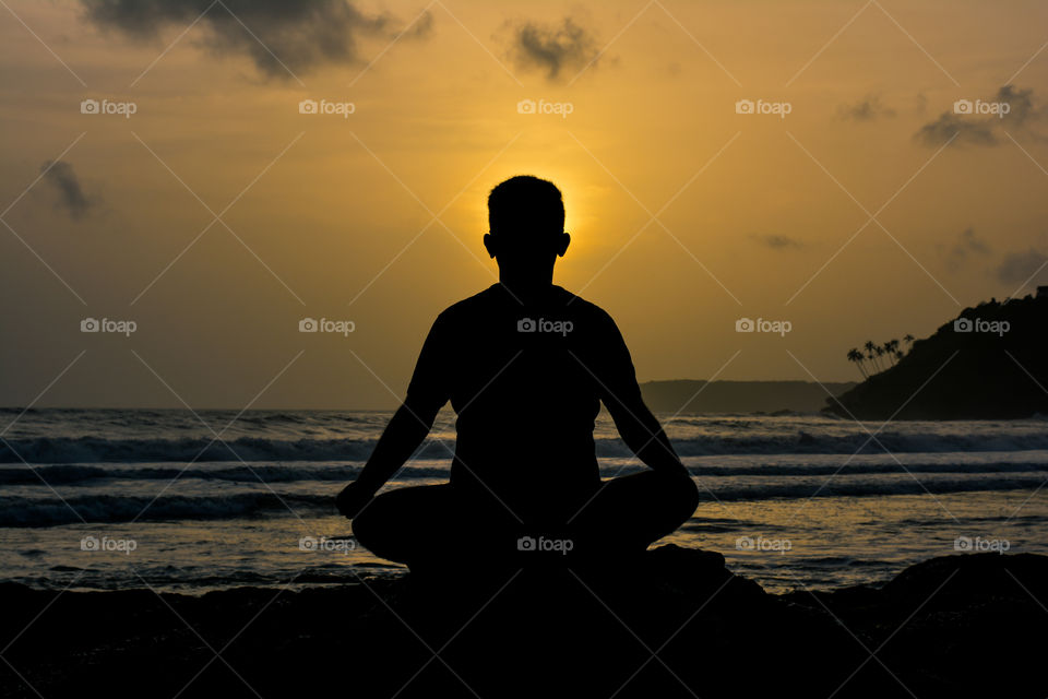 Meditation on a beach at sunset