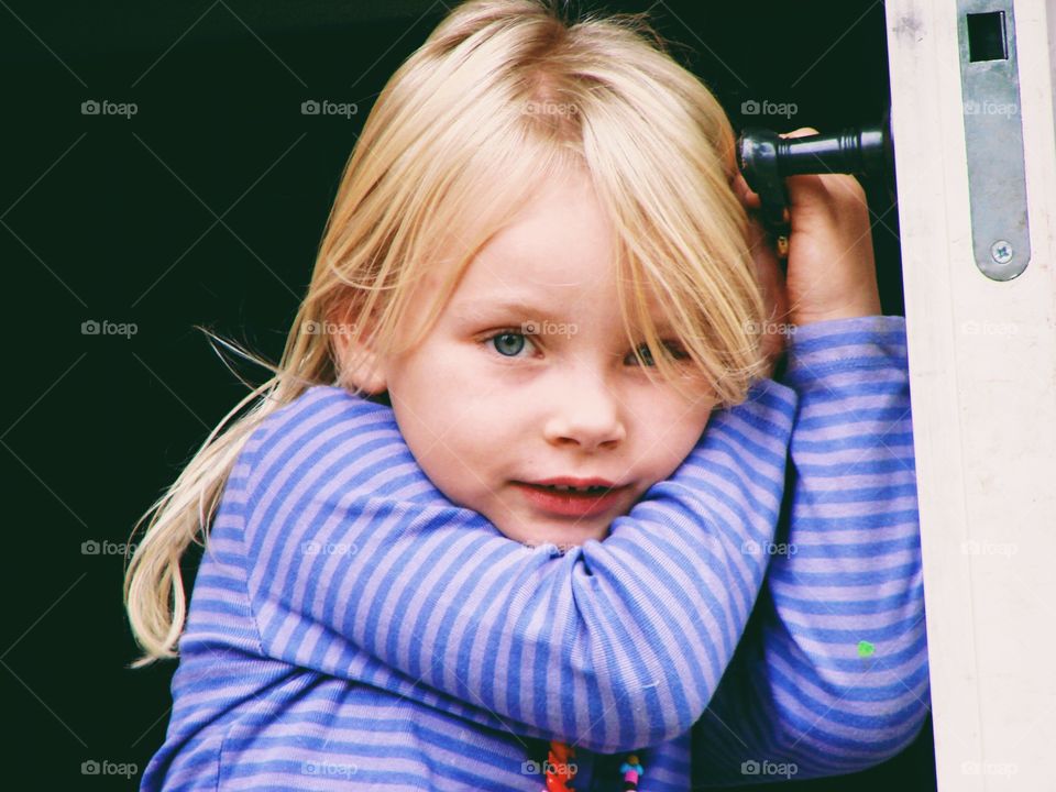 Girl welcoming at the door with a shy expression