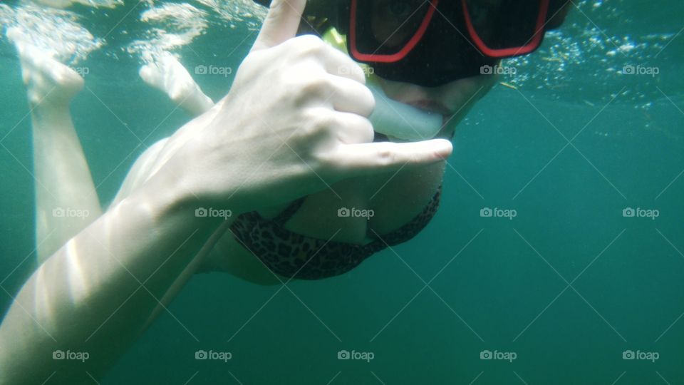 Female scuba diver showing shaka sign underwater