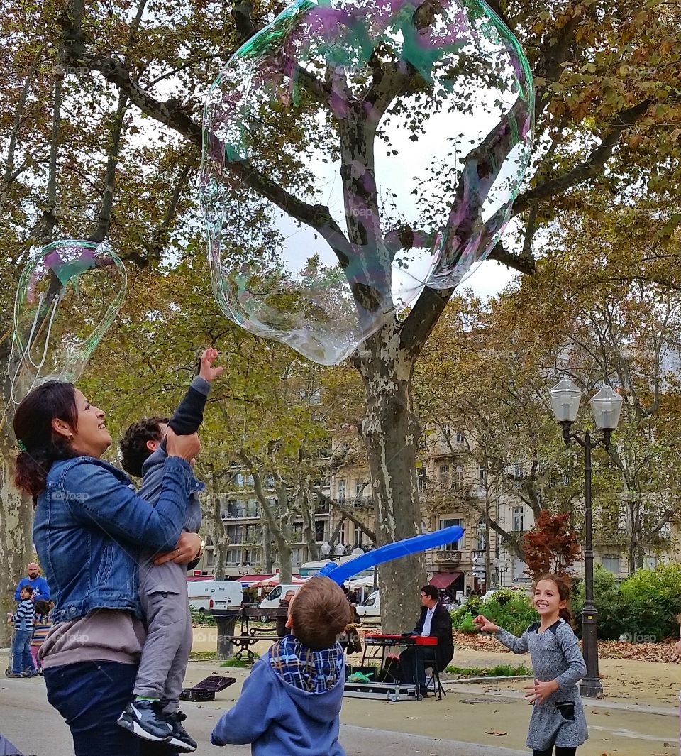 kid reaching to a bubble