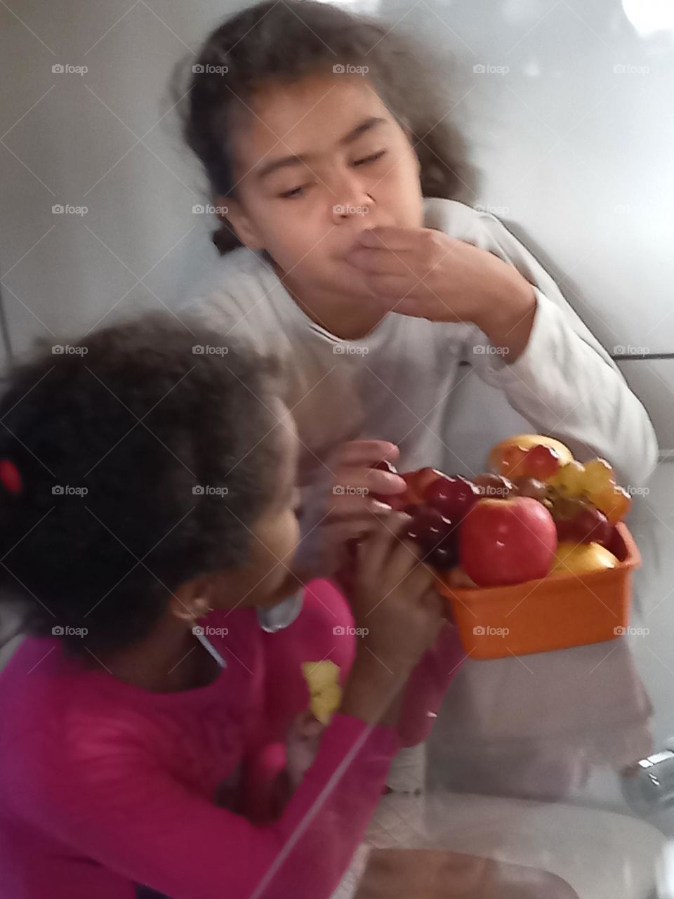 Editorcoice the Photo week Crianças sentadas comendo frutas: maçãs e uvas doces e saborosas