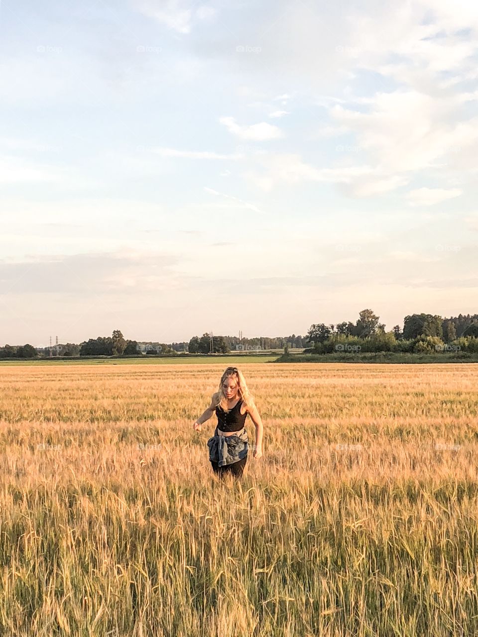 Girl standing in a field of wheat 