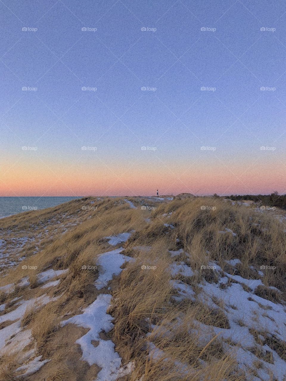 Sunset, dunes at Lake Michigan, blue& pink sky, lighthouse in the background 