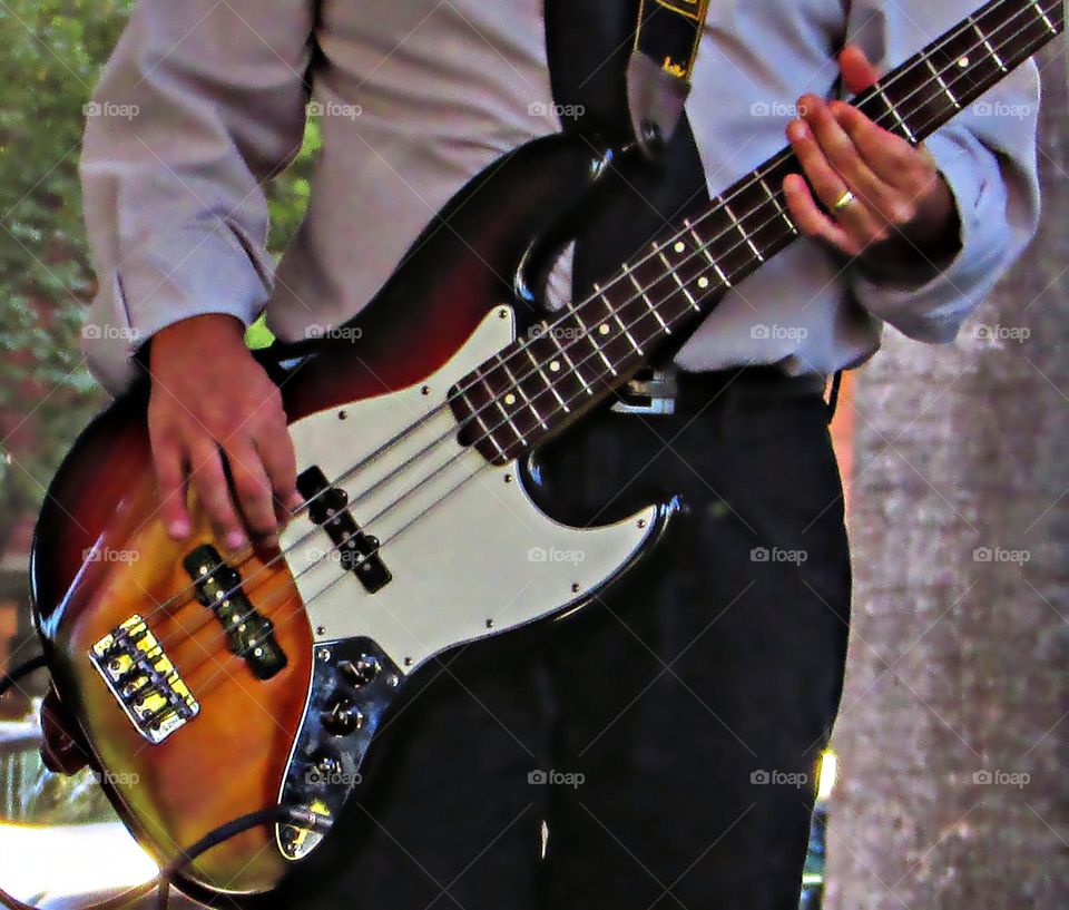Musician playing a bass in a outdoor concert in  Sacramento California