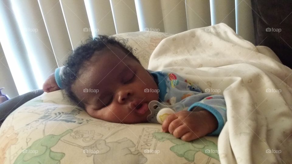 African baby sleeping on bed