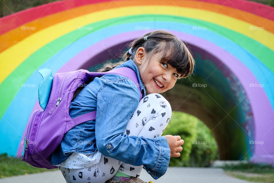 Cute smiling girl on a rainbow background