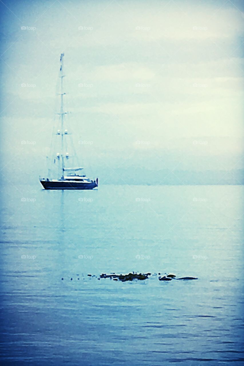 Morning stillness and a solitary boat upon calm pale blue waters invite one to slowly absorb the day and her sacred promises. 