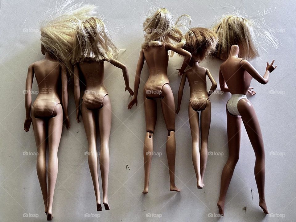 Various versions of vigorously played with Barbie dolls sans clothes can symbolize the bond of tenderness between parents and children through the evocative magic of photography 