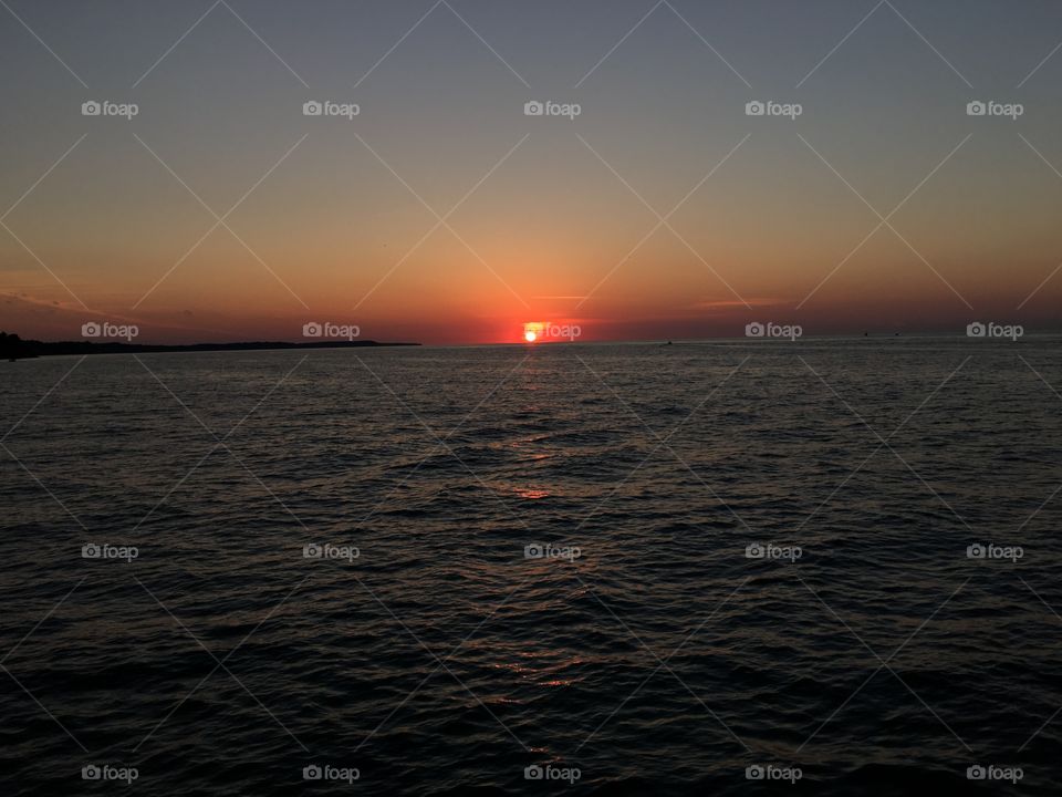 The sun touching the water at Sodus Point NY. 