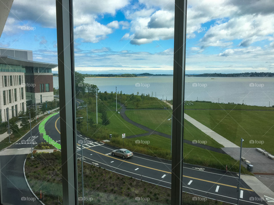 Window view of the road at UMass Boston on a beautiful day looking out. 