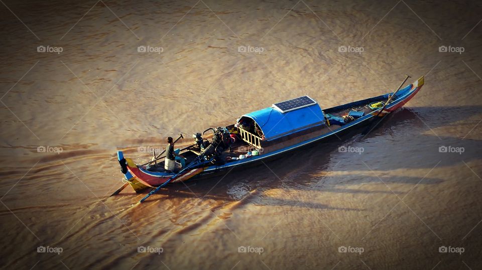 A watercraft plowing the waters of the mighty Mekong river in the city of Phnom Penh 