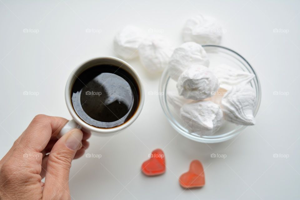 coffee mug and sweet sugar meringues on a white background top view