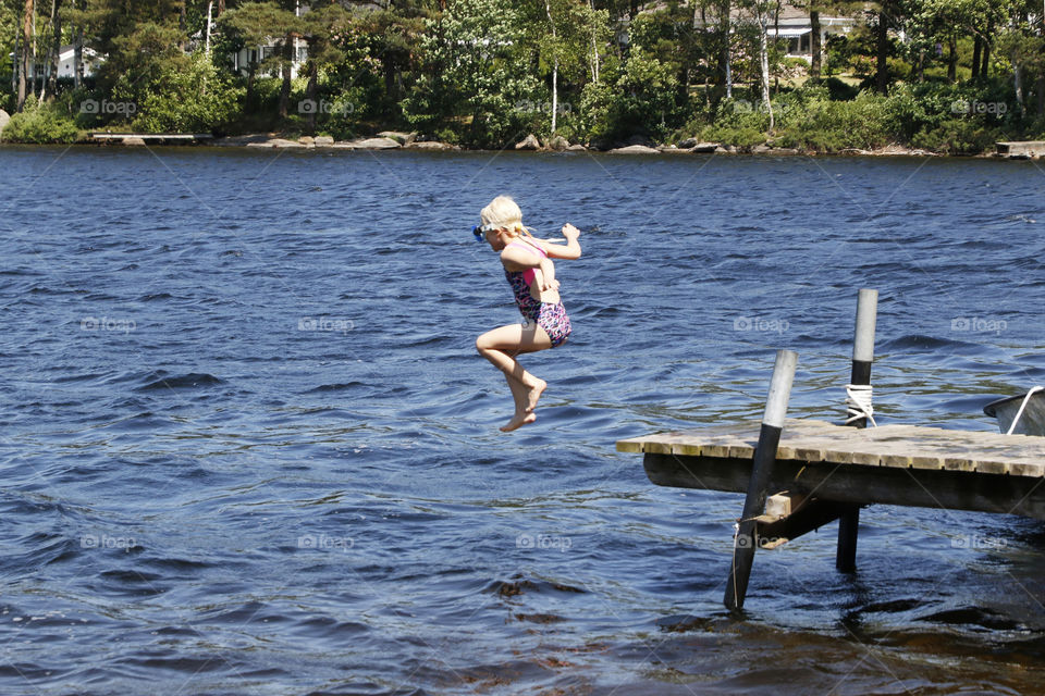 Jumping into the water from a wooden pier in June 