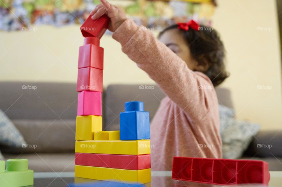 little girl playing rectangular colored constructions