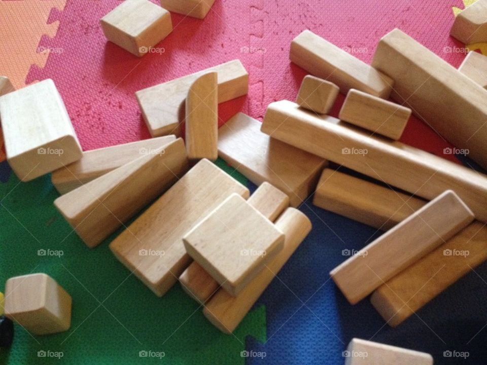 Wood blocks toys on a child's play mat.