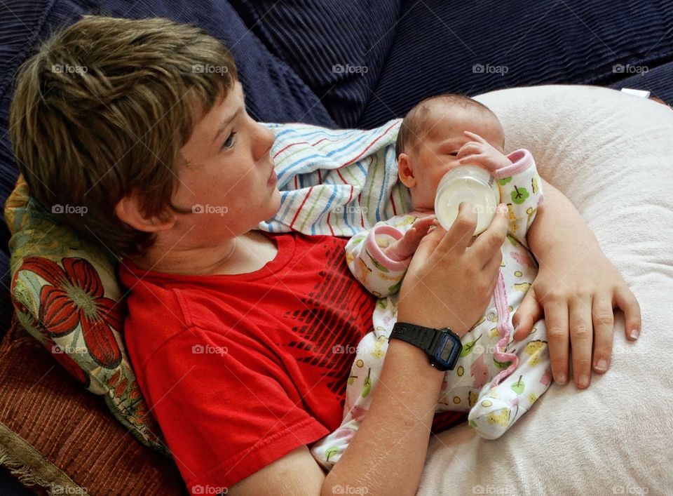 Young Boy Holding His Newborn Baby Sister
