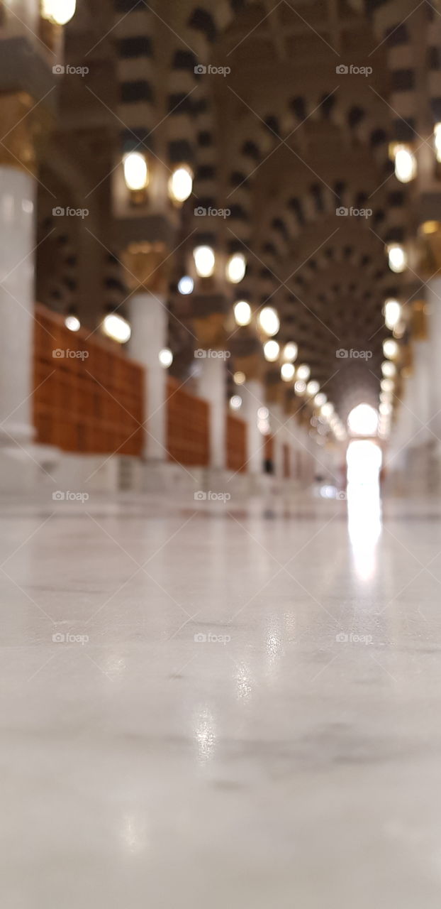 This is one of the long corridors in the Madina Holy Mosque in Saudi Arabia. It is the mosque of Prophet Muhammad (peace be upon him), the Prophet of Islam and muslims. 

The photo can be used in holidays cards, and to represent long pathways & roads