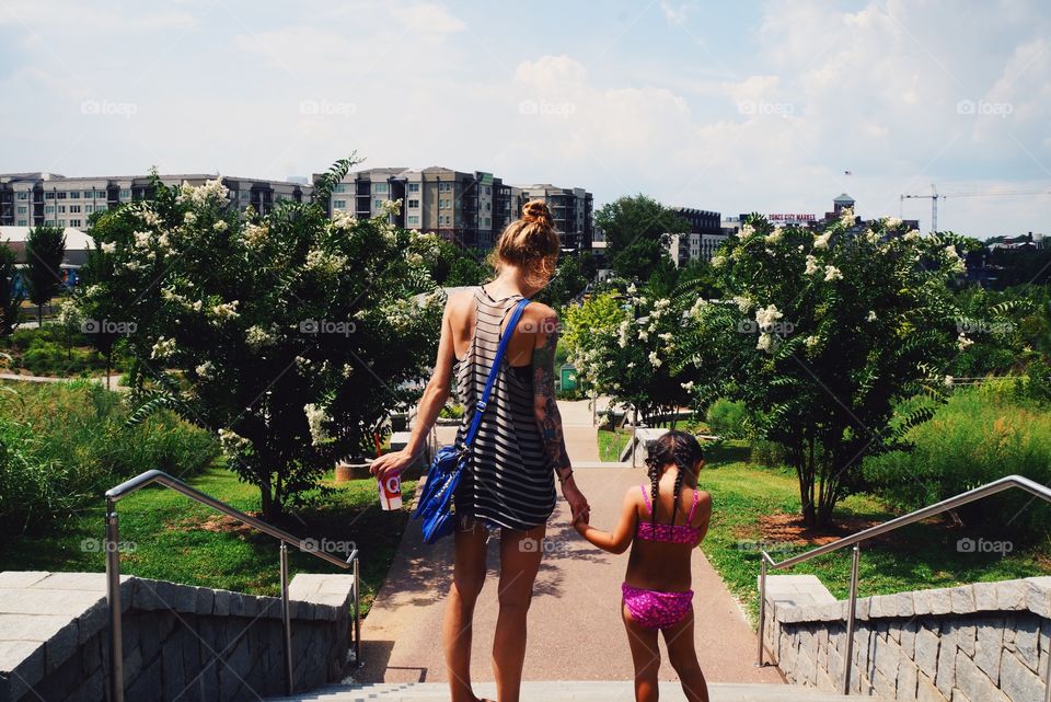 Rear view of mother and daughter standing on staircase