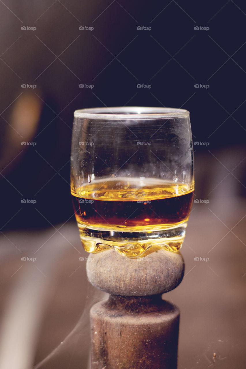 spooky glass of whiskey. glass of whiskey spookey  standing on  barrel cap with spider net bellow