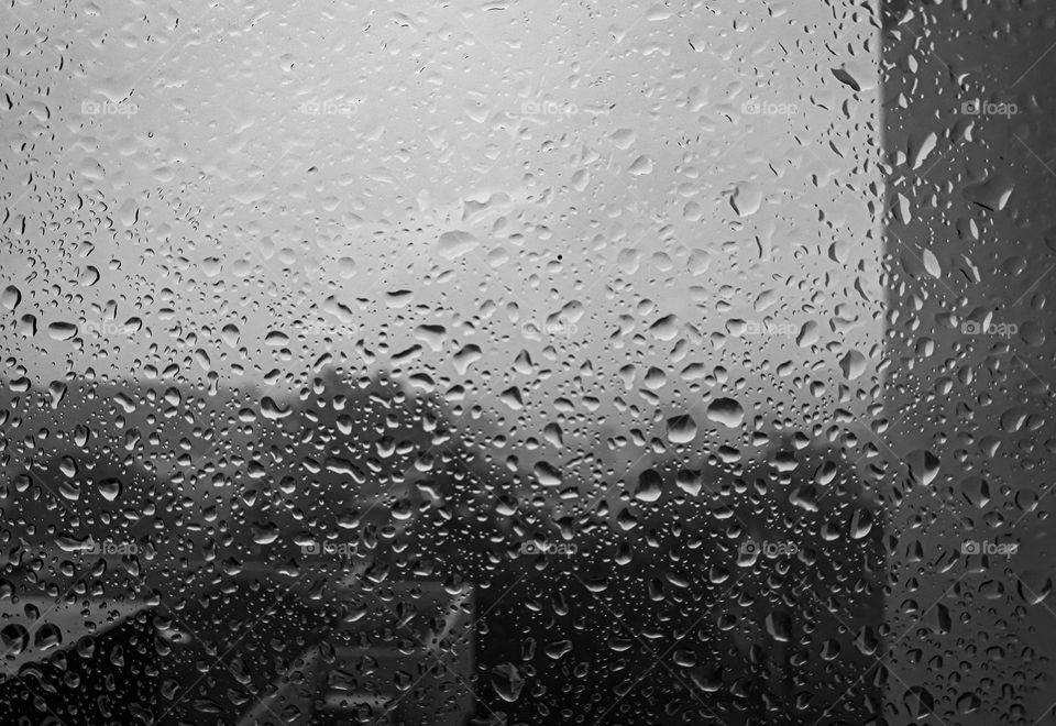 Pequenas gotas de chuva no vidro de uma janela.