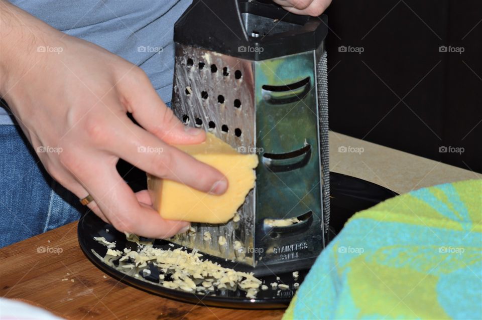 Close-up of a man grating cheese