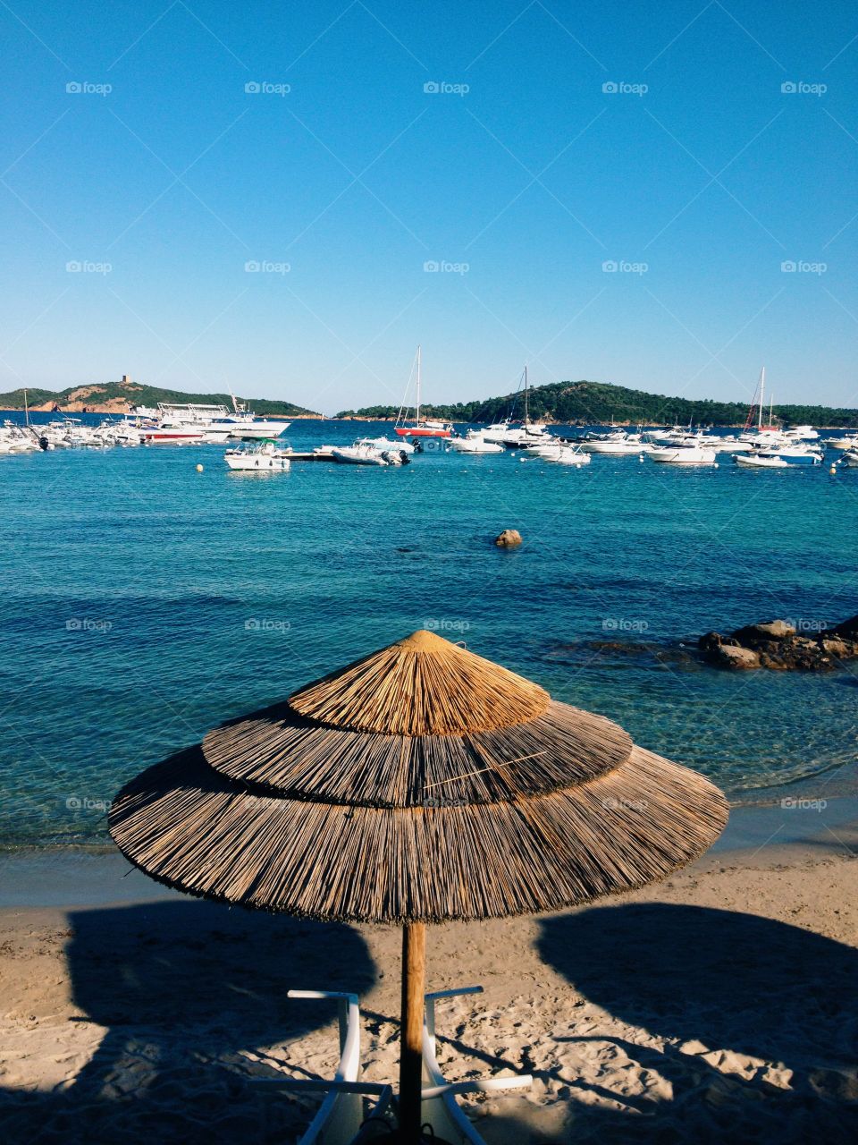 Thatch roof umbrella on a beach in Corsica 