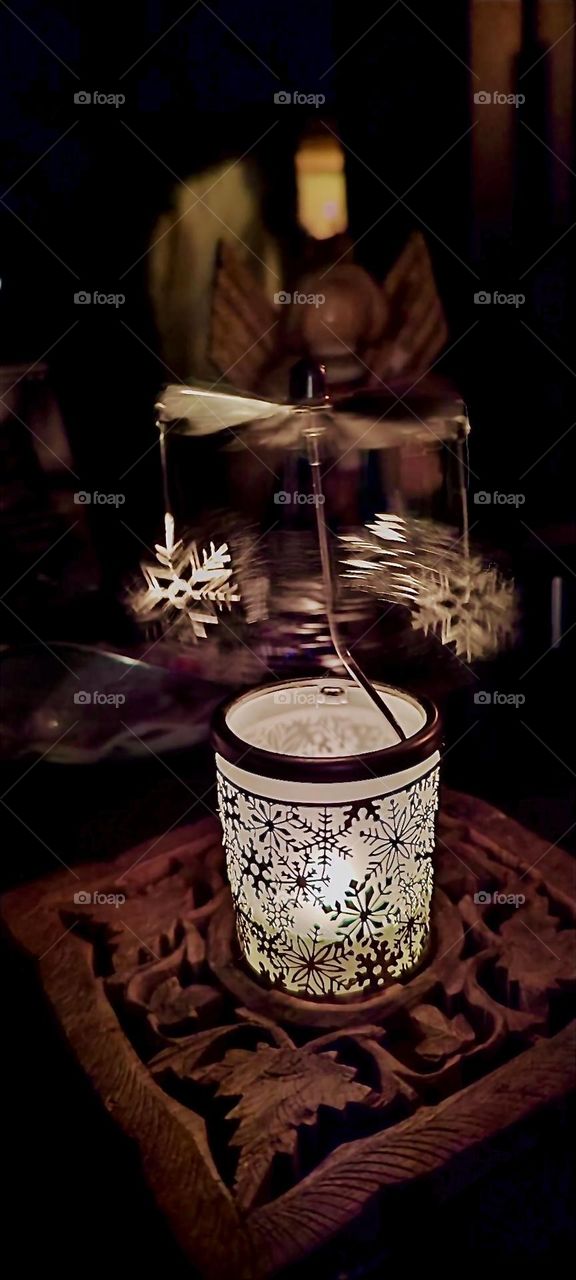 This is a mobile of sorts that uses the principle of a wind turbine in miniature. Because heat rises light weight silver snowflakes are set into circular motion by the warmth of the candle inside the lantern when it’s lit. 2023. Hypnotic Productions