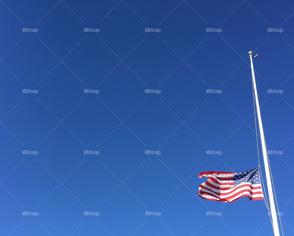 flag of United States of America at half mast in the wind