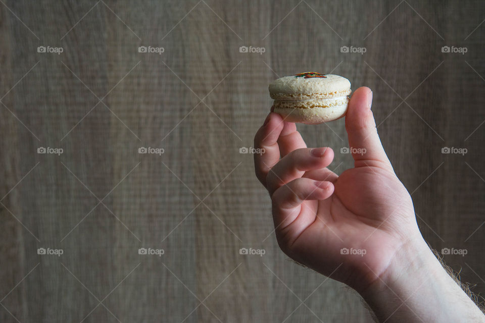 Human hand holding macaroon