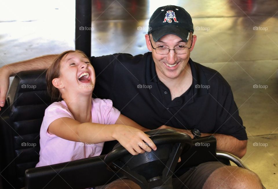 Absolute fun. Love their expressions - father and daughter having fun on the bumper cars