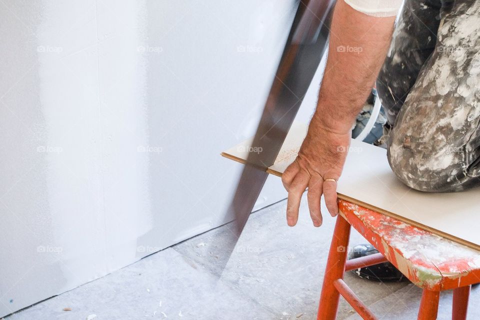 Man sawing a floor board