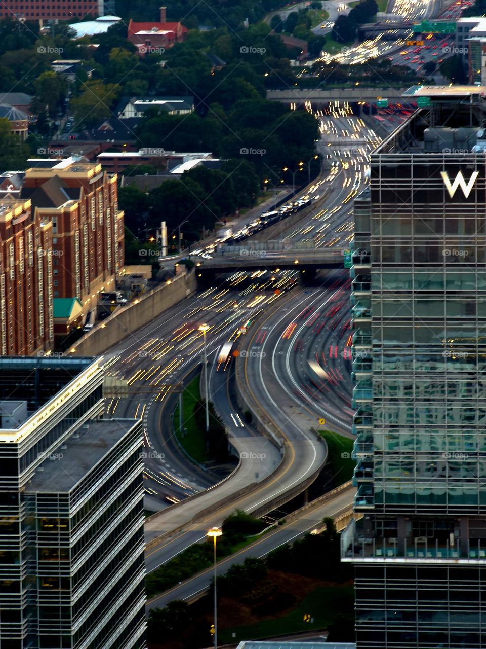 Rush hour traffic streams through a downtown freeway maze reflecting the speed and complexity of modern life