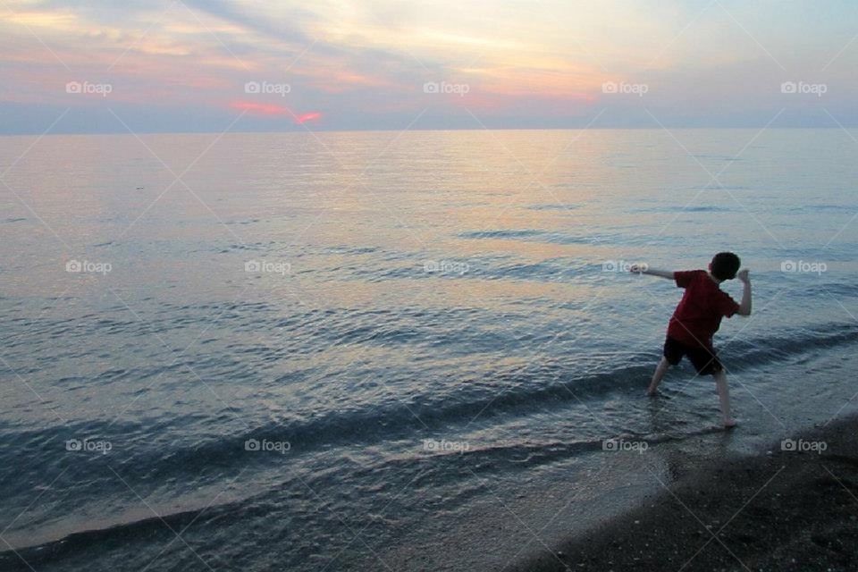 Boy skipping stones 