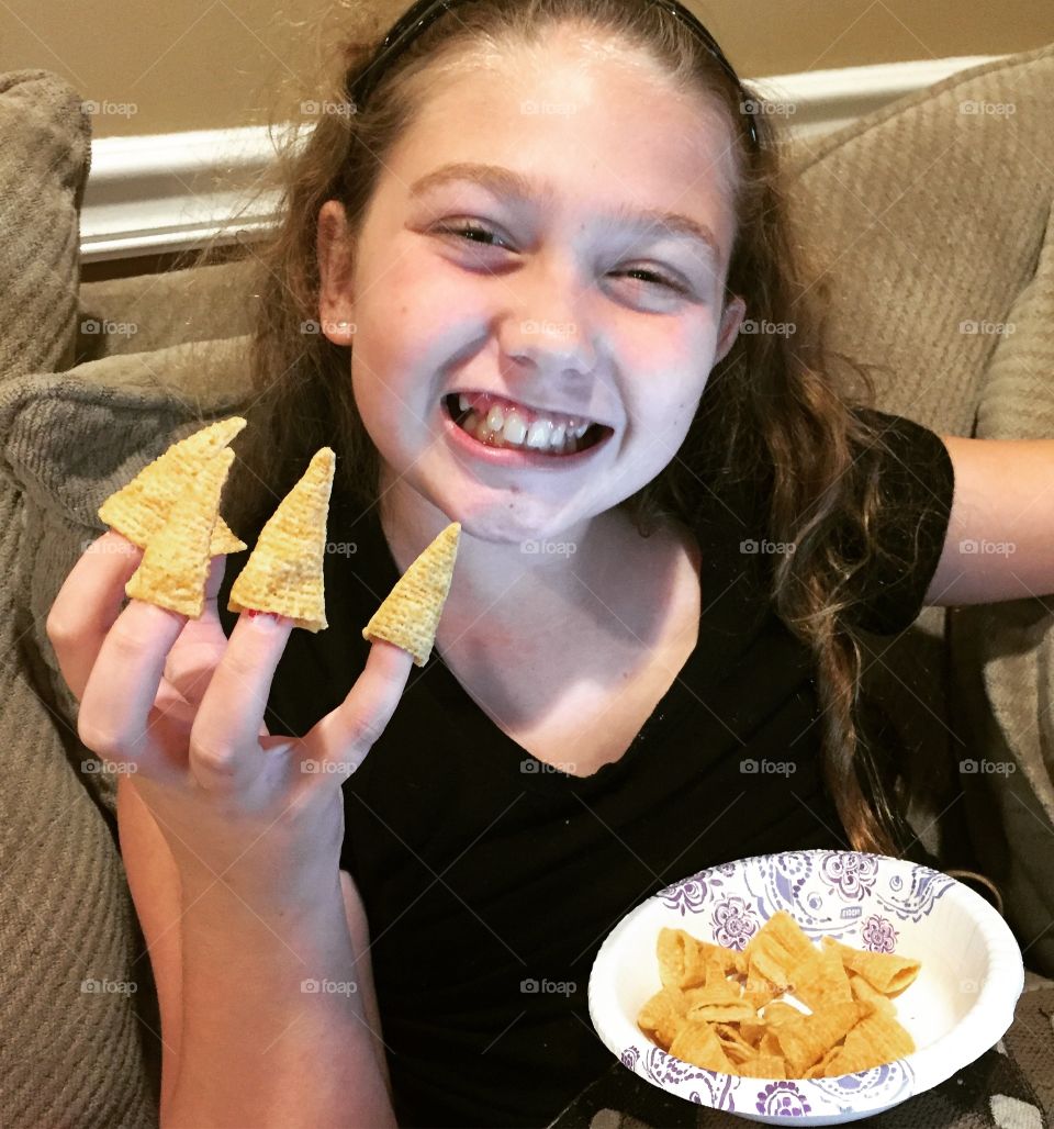 Girl holding snack in her fingers