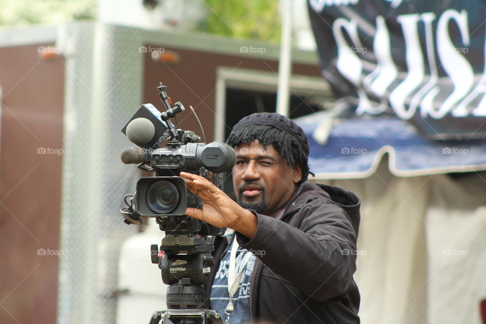 Man doing videography using video camera while shooting for a news channel 