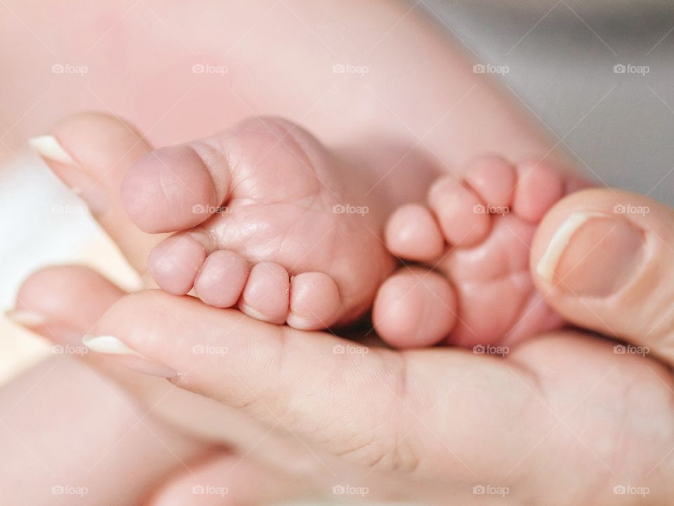 Women's hand holding babies foot
