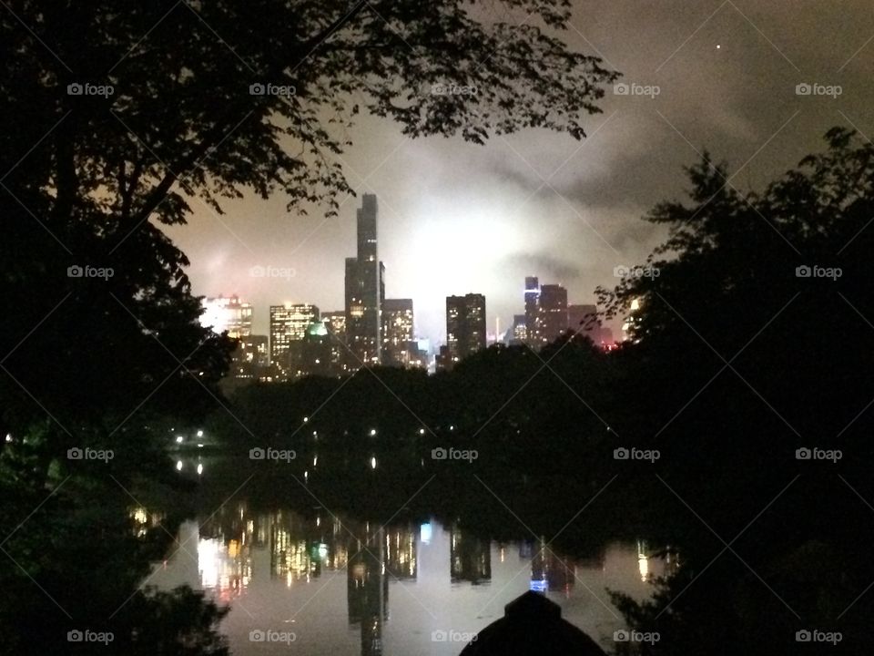 Building reflecting on a lake at night in Central Park 