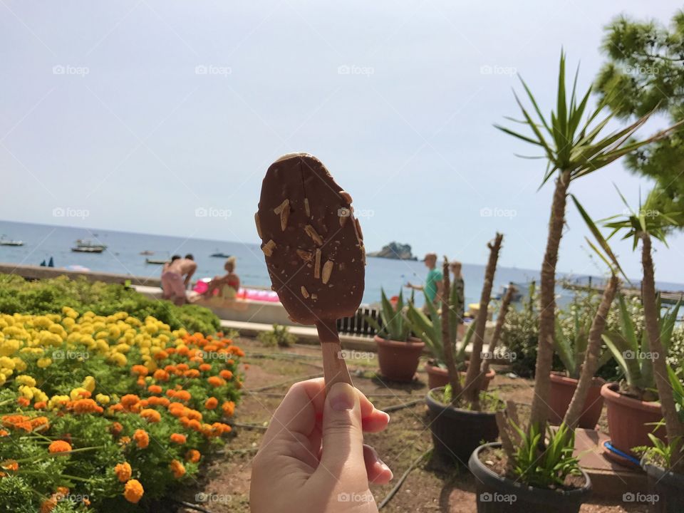 Chocolate ice cream beside the seaside with a gorgeous view of the sea and the sky and the beautiful Mediterranean plants and flowers. This describes perfect summertime.